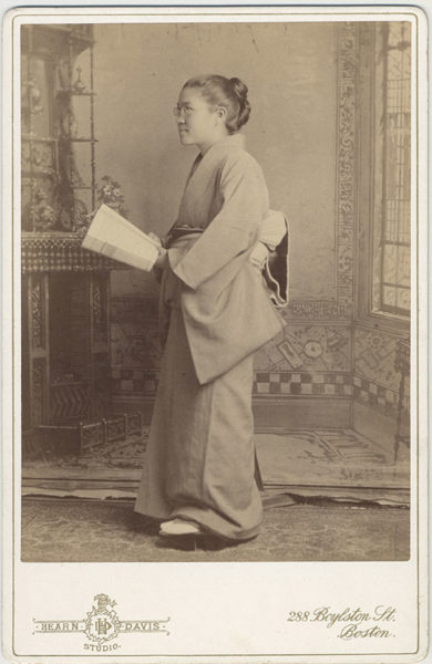 Full-length portrait of Toshi Miyagawa, class of 1893, in Japanese dress, holding book.