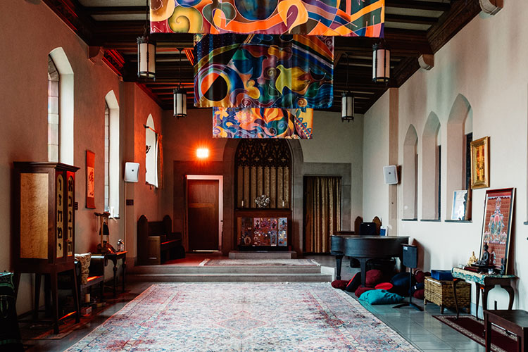 Chapel with light coming in on left side and colorful banners hanging from the ceiling