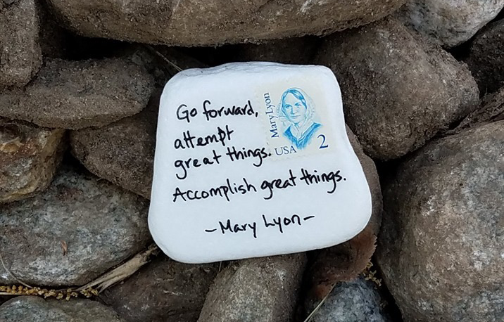 A rock painted white with a Mary Lyon two cent stamp quotes the founder: "Go forward, attempt great things. Accomplish great things."